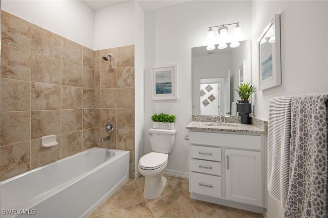 Bathroom featuring toilet, vanity, baseboards, and shower / washtub combination | Image 35