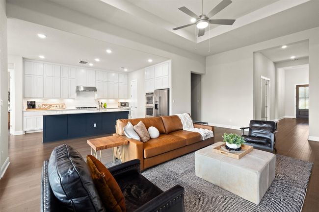 Living room with ceiling fan, dark wood-style flooring, and recessed lighting | Image 15