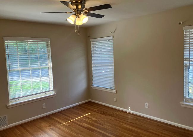 Unfurnished room featuring plenty of natural light, wood finished floors, and a ceiling fan | Image 6