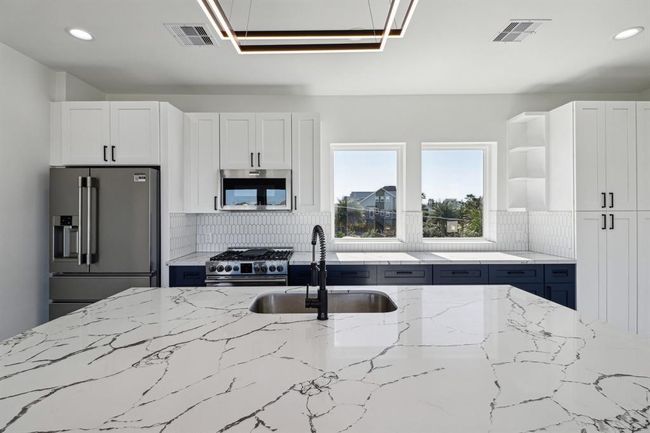 Custom cabinets and beautiful quartz countertops in the kitchen combining functionality with elegant design | Image 10