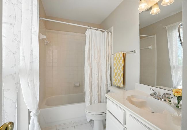 Bathroom featuring vanity, shower / bath combination with curtain, and tile patterned flooring | Image 27