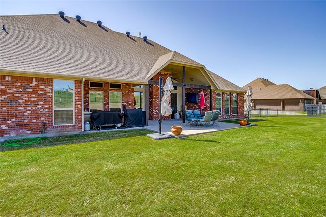 Rear view of property with brick siding, a lawn, and a patio area | Image 30