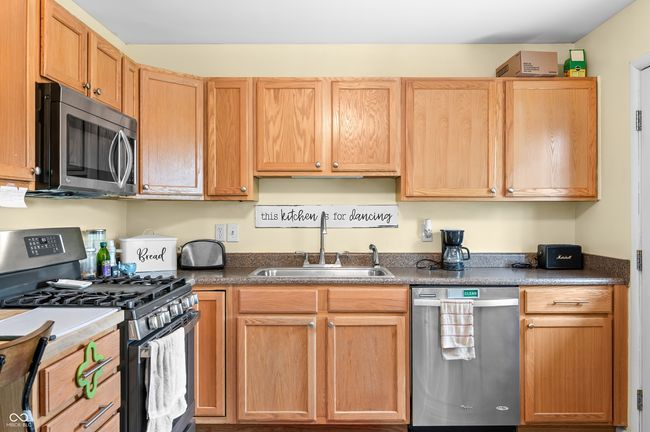 kitchen with dark countertops, appliances with stainless steel finishes, and a sink | Image 17
