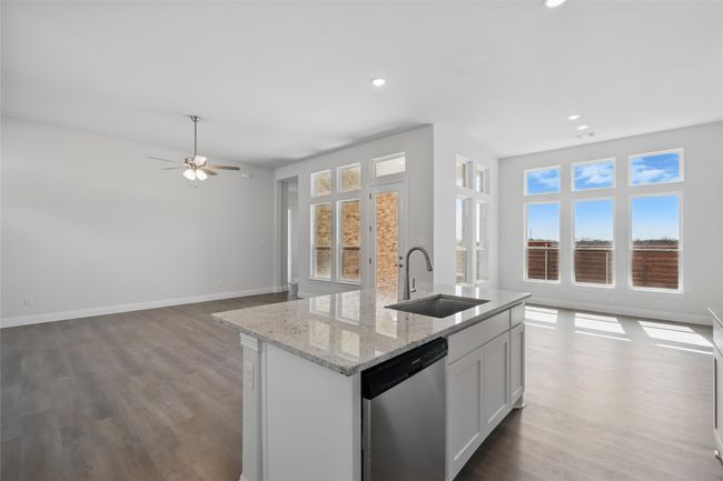 Kitchen featuring a kitchen island with sink, open floor plan, dishwasher, and a sink | Image 6
