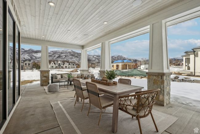 Sunroom / solarium featuring wooden ceiling, a residential view, and a mountain view | Image 17