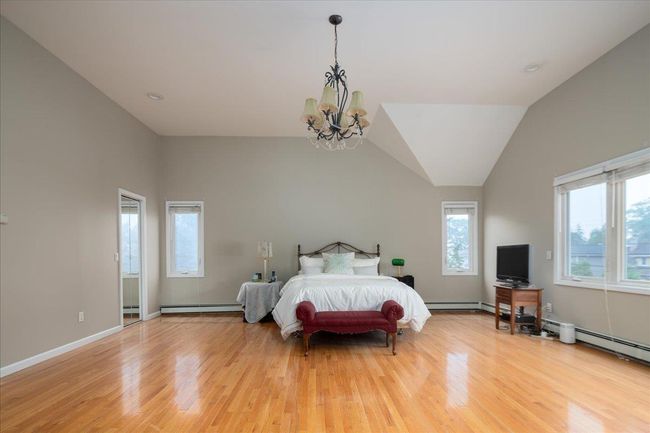 Bedroom featuring a chandelier, light wood-style floors, baseboard heating, and a baseboard radiator | Image 20