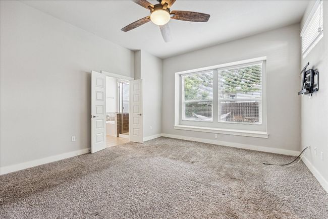 Unfurnished bedroom featuring carpet flooring, baseboards, ensuite bathroom, and a ceiling fan | Image 15