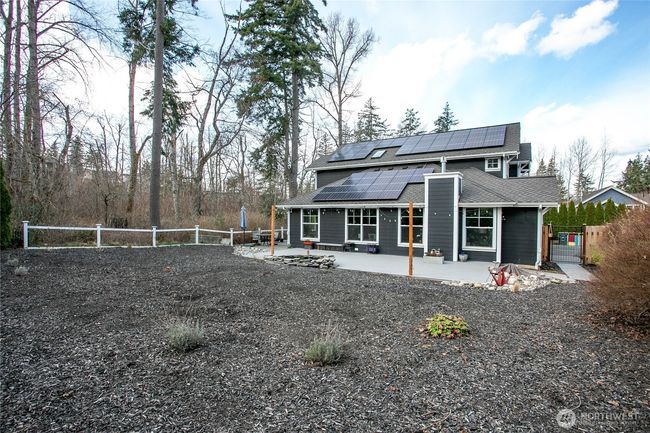 Looking at the side of the house with the newly installed 30-panel solar setup, new deck and custom pond. | Image 36