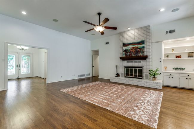 Built in shelving, lots of wall space to hang your art, and gorgeous oak floors just reinvigorated, built in speakers in the ceiling, new lighting and fresh paint make this huge room feel like new construction! | Image 5