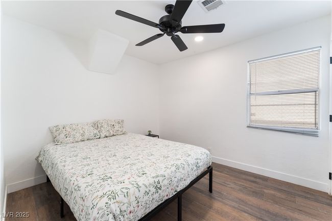 Bedroom featuring baseboards, dark wood-style floors, and visible vents | Image 23