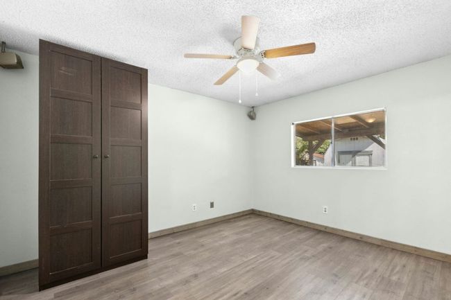 Unfurnished bedroom featuring a textured ceiling, light wood-style flooring, a closet, and a ceiling fan | Image 25