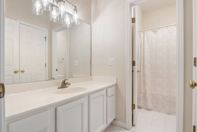 Secondary bath has large vanity with lots of cabinets, updated lighting and plumbing hardware with fresh paint. Toilet and bath are separated from sink and vanity so multiple family members can share the space on busy mornings. | Image 20