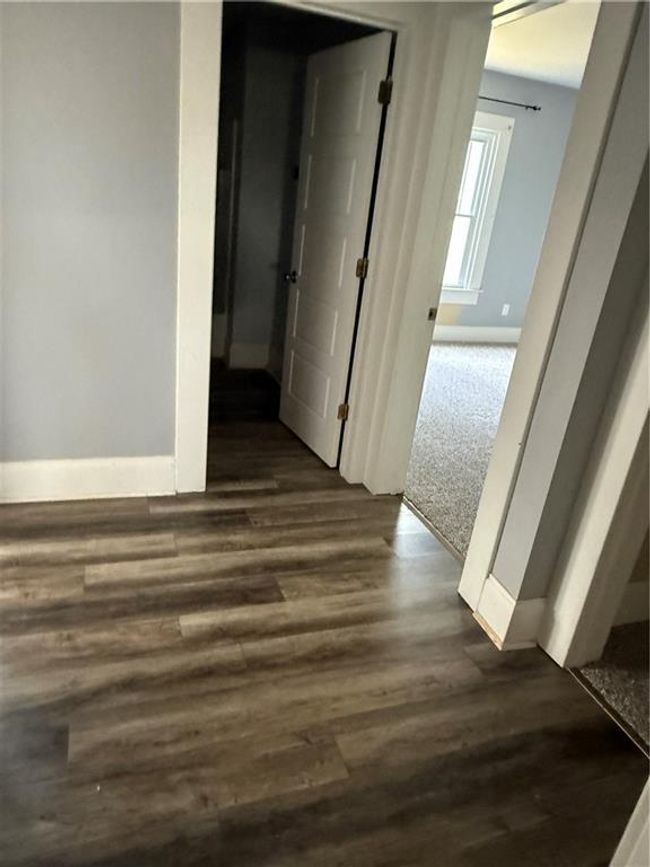 Corridor featuring baseboards and dark wood-style flooring | Image 12