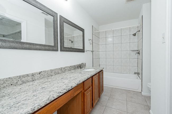 Bathroom with visible vents, toilet, vanity, shower / bathtub combination, and tile patterned floors | Image 17