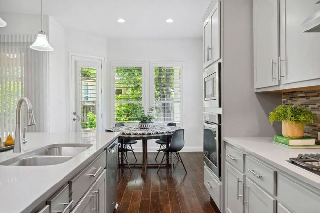The kitchen seamlessly transitions to a casual dining space. | Image 16