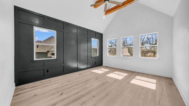 Unfurnished bedroom featuring light wood finished floors, a decorative wall, high vaulted ceiling, and baseboards | Image 21