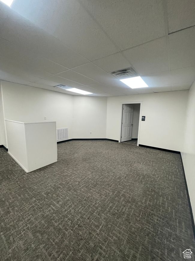 Below grade area featuring carpet flooring, a paneled ceiling, baseboards, and visible vents | Image 8