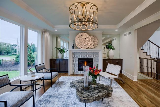 Living room featuring a fireplace, crown molding, hardwood / wood-style flooring, and a chandelier | Image 6