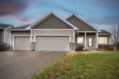 Front of the property with 3-Car garage and porch. Twilight photo. | Image 1