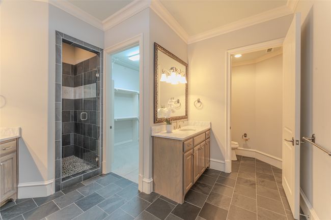 Full bathroom featuring vanity, a stall shower, tile patterned floors, and crown molding | Image 27