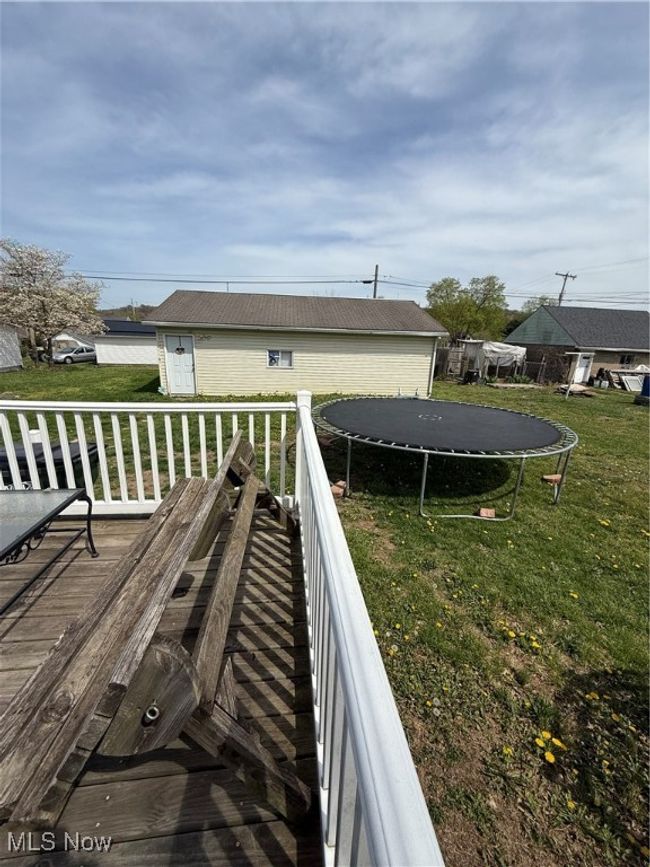 Wooden deck featuring a lawn and a trampoline | Image 26