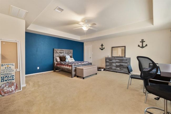 Right upstairs the game room features plush carpet, accent wall, custom paint, high ceiling, and ceiling fan. | Image 17