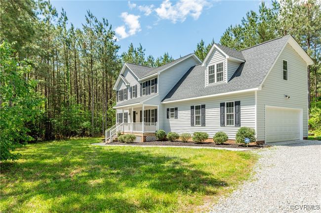 View of front of home featuring a porch, an attached garage, driveway, a front lawn, and roof with shingles | Image 32