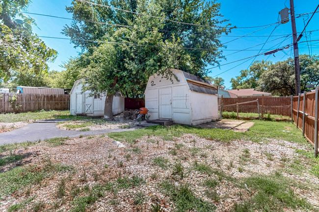 Fenced backyard featuring a storage unit | Image 32