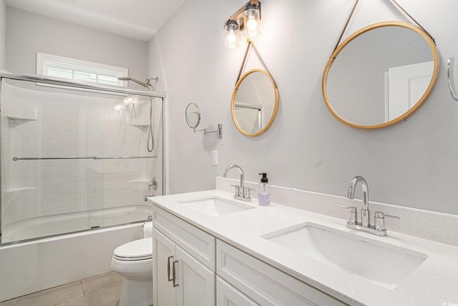 Full bathroom featuring double vanity and combined bath / shower with glass door | Image 25