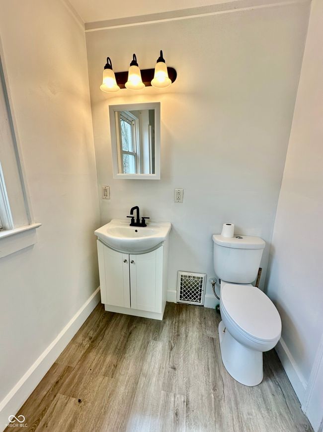 bathroom featuring vanity, visible vents, toilet, wood finished floors, and baseboards | Image 38