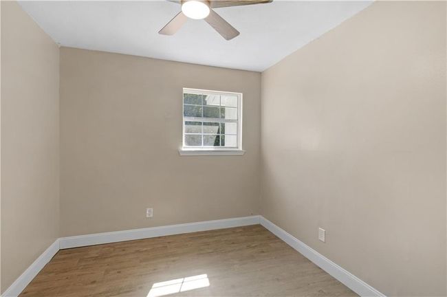 Spare room with ceiling fan, baseboards, and light wood-style flooring | Image 12