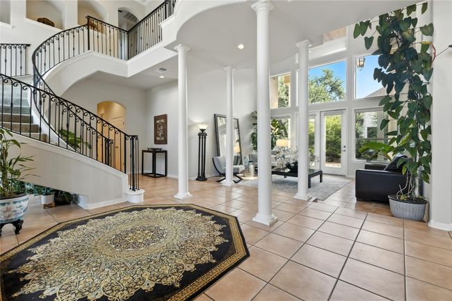 Tiled foyer with decorative columns, a high ceiling, stairs, and recessed lighting | Image 13