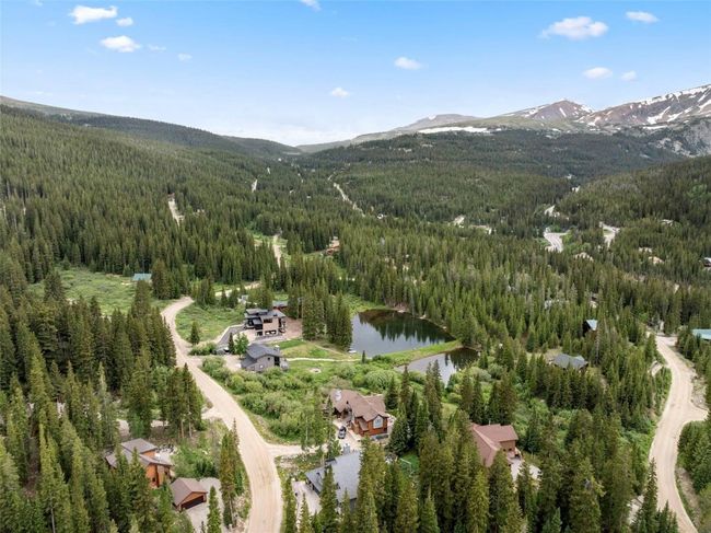 Aerial overview of property's location featuring a forest and a water and mountain view | Image 39