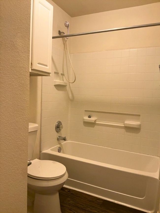 Full bath with bathtub / shower combination, dark wood-style flooring, and a textured wall | Image 14