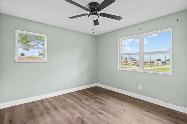 Empty room with baseboards, wood finished floors, and ceiling fan | Image 13