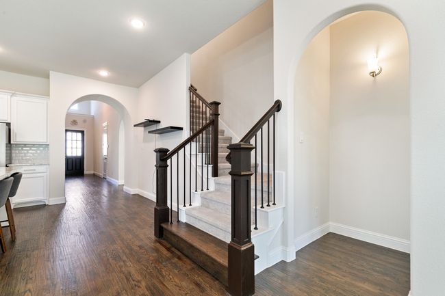 Foyer entrance featuring baseboards, stairway, arched walkways, and dark wood-type flooring | Image 10