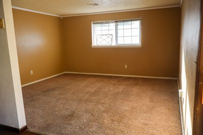 Empty room featuring crown molding, carpet, and a textured ceiling | Image 2