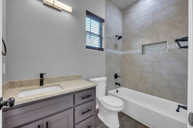 Full bathroom featuring vanity, toilet, and tiled shower / bath | Image 22