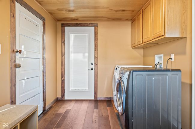 laundry room with dark wood-style flooring, cabinet space, independent washer and dryer, and wood ceiling | Image 48