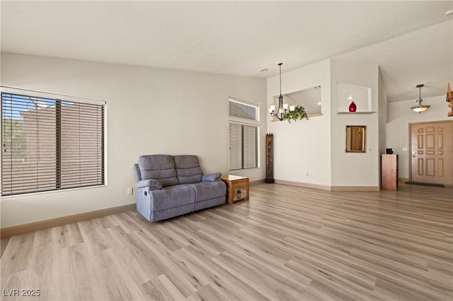 Living area with light wood finished floors, a chandelier, and high vaulted ceiling | Image 21