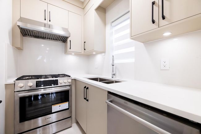 Kitchen featuring appliances with stainless steel finishes, range hood, light countertops, and white cabinets | Image 16