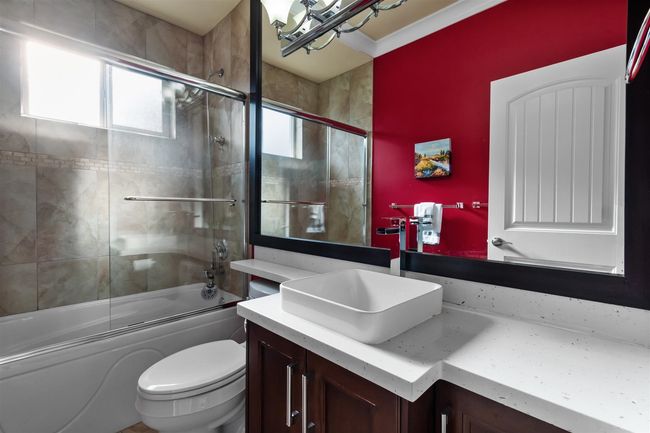 Bathroom featuring vanity, enclosed tub / shower combo, and toilet | Image 26