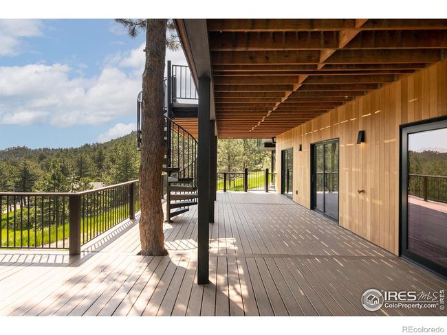 Seamless indoor-outdoor living with an expansive two-story deck connected with a spiral staircase and unobstructed views | Image 32