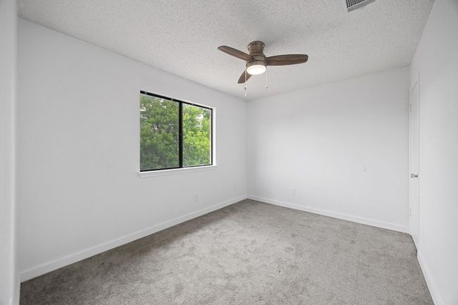 Unfurnished room with carpet, a ceiling fan, baseboards, and a textured ceiling | Image 20