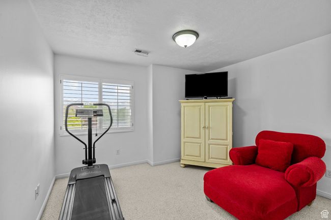 Exercise room featuring a textured ceiling, visible vents, baseboards, and carpet | Image 29