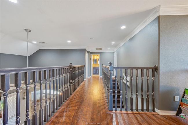 Corridor featuring wood finished floors, an upstairs landing, ornamental molding, and recessed lighting | Image 25