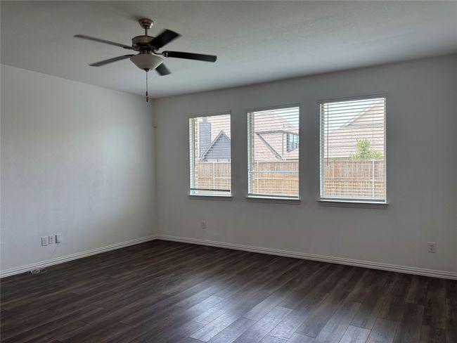 Unfurnished room with dark wood-type flooring, baseboards, and a ceiling fan | Image 7