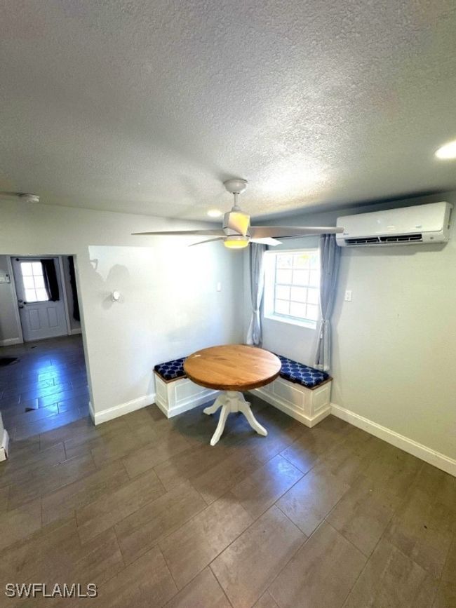 Unfurnished dining area featuring a wall mounted air conditioner, plenty of natural light, and wood finished floors | Image 8