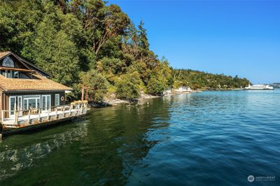 This charming home sits right down on the water with 170 feet of shoreline. Solar panels on the roof capture the all-day sunshine. | Image 1