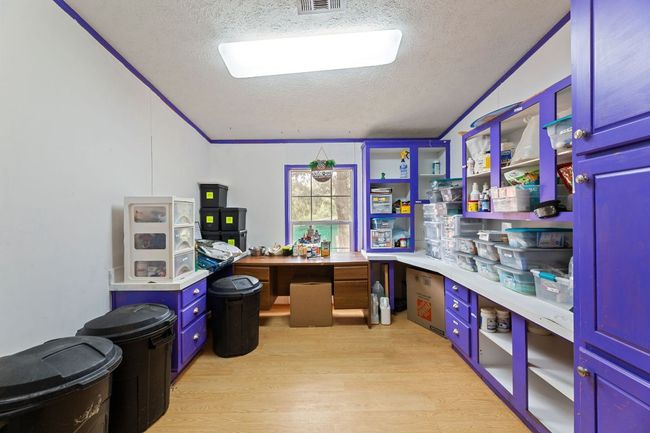 Office with a textured ceiling, light wood-style floors, and vaulted ceiling | Image 4